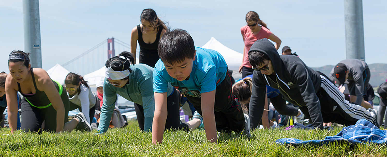 Children doing push ups outside. 